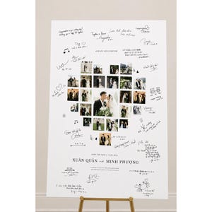 May include: A white rectangular wedding guest book sign featuring a central heart-shaped collage of various photographs of a couple. The board includes the text "ALWAYS AND FOREVER", "SAVE THE DATE | 15.08.2023", and "XUÂN QUÂN and MINH PHƯƠNG".