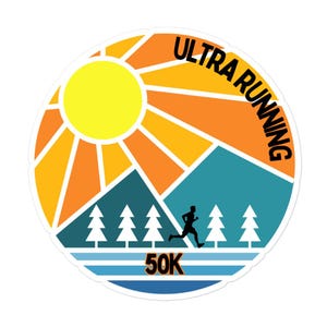 May include: A circular sticker with a design for ultra running. The design features a yellow sun, orange rays, blue mountains, green trees, and a runner. The text "ULTRA RUNNING" and "50K" are included in the design.