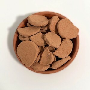 a bowl filled with brown rocks sitting on top of a table