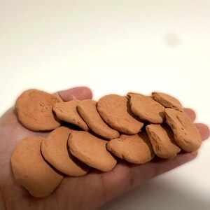 a hand holding a pile of cookies on top of a table