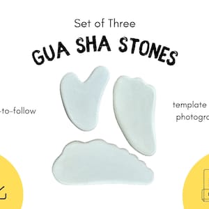 Könnte beinhalten: Set von drei weißen Gua Sha Steinen, geformt wie ein Herz, eine Träne und eine Wolke. Die Steine befinden sich auf einem weißen Hintergrund mit dem Text "Set of Three GUA SHA STONES" darüber. Der Text "easy-to-follow template with photographs" befindet sich unter den Steinen. Ein gelbes Quadrat mit einem Download-Symbol befindet sich in der linken unteren Ecke. Ein gelbes Quadrat mit einem PDF-Symbol befindet sich in der rechten unteren Ecke.