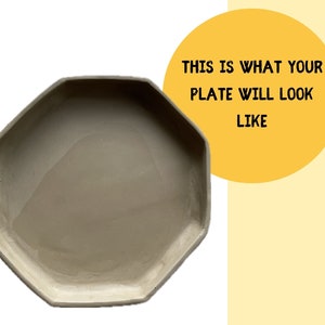 May include: A light gray octagonal ceramic plate. The plate is smooth and has a slightly textured surface. "This is what your plate will look like" is written in black text on a yellow circle.