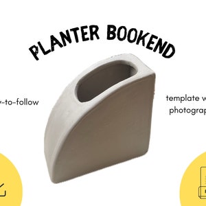 May include: A white planter bookend with a rectangular shape and a curved top. The bookend has a small planter on the top for a small plant or succulent. The text "PLANTER BOOKEND" is written in black letters on a white background.