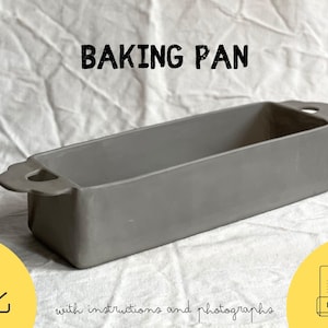 Puede incluir: Una bandeja para hornear rectangular gris con asas. El texto "BAKING PAN" está encima de la bandeja. Debajo, el texto "with instructions and photographs".