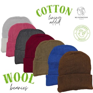 May include: A collection of wool beanies in various colors, including gray, pink, charcoal, burgundy, olive, blue, and brown. The beanies have a ribbed knit texture and a folded cuff. The image also includes text that says "Cotton lining added" and "Wool beanies".
