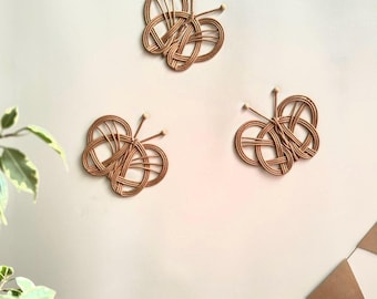 May include: Three brown woven butterfly wall decorations on a white background.