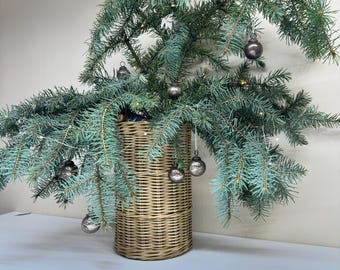 May include: A wicker basket filled with a green fir tree branch decorated with silver baubles.