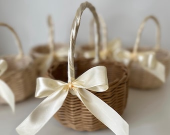 Cestino beige per damigella d'onore con manico e fiocco. Decorazione rustica rotonda bianca per matrimoni.