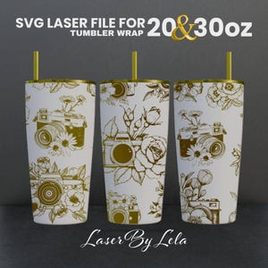 May include: Three white tumblers with gold lids and gold designs of cameras and flowers. The tumblers are 20 and 30 ounces. The text "SVG Laser File for 20 & 30 oz Tumbler Wrap" and "Laser By Lela" are on the image.