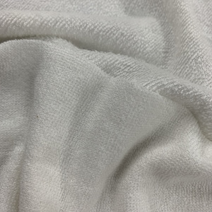 May include: Close-up of a white, soft, and textured fabric. The fabric has a slightly raised surface, giving it a fuzzy appearance.
