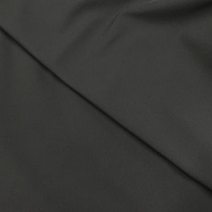 May include: A close-up of a dark gray fabric with a smooth texture. The fabric is folded in half, creating a diagonal line.