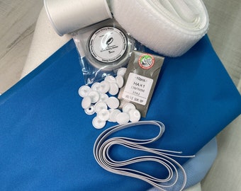 May include: A set of sewing supplies including white thread, white snaps, white elastic, white fabric, blue fabric, and a package of needles. The package of needles has the text "10pcs - HAX1 130/705H 13X1 80/12 5Ux BP".