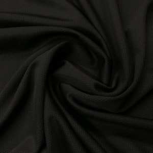May include: Black athletic fabric with a textured, breathable weave. The fabric is draped and folded, showing its flexibility and drape.