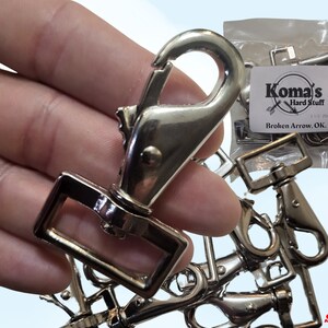 May include: A bag of 10 silver-toned metal swivel snap hooks. The bag is labeled "Koma's Hard Stuff 10 Count Bag".