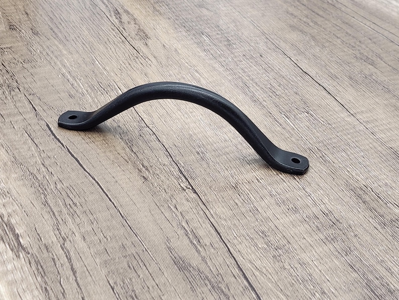 Puede incluir: Pomo de metal negro con forma curva. El pomo mide aproximadamente 38 cm de largo.