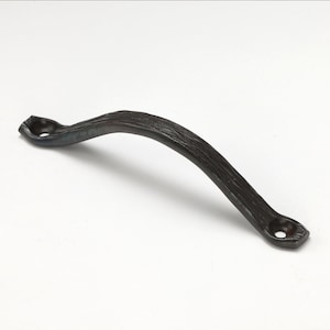 May include: A dark brown, arched cabinet pull with a textured, wood-grain appearance. The handle has a curved design with mounting holes at each end. The hardware is made of metal and is suitable for furniture or cabinetry.