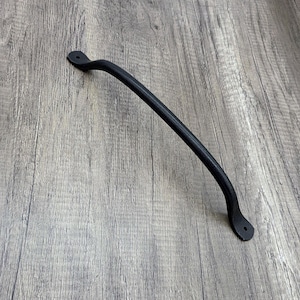 May include: Black metal door handle with a curved design. The handle has a smooth, matte finish.