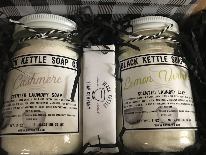 May include: Two glass jars of laundry soap, one labeled "Cashmere" and the other "Lemon Verbena", with a bar of soap labeled "Black Kettle Soap Company" in the middle. Each jar contains 8 ounces of soap and makes 16 loads.