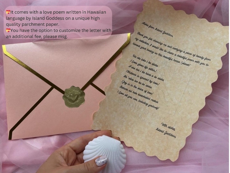 May include: A light pink envelope with gold trim and a gold wax seal featuring a heart, accompanied by a piece of parchment paper with scalloped edges containing a poem in Hawaiian and English, and a white seashell-shaped object.