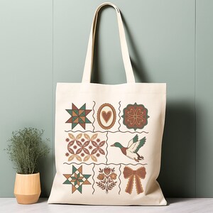 May include: Cream tote bag with a patchwork design. The bag features illustrations of stars, hearts, flowers, a duck, and a bow. The bag has long handles for carrying. The bag's design is reminiscent of a quilt.