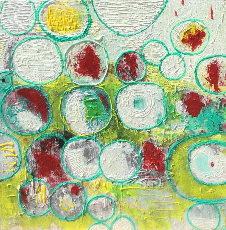 May include: Abstract painting with a green, yellow, and white background. The painting features a variety of overlapping circles in different sizes and colors, including red, white, and green.