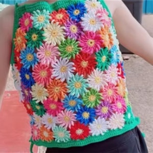 Könnte beinhalten: Ein grünes Häkeltop mit Blumenmuster. Das Oberteil besteht aus bunten gehäkelten Blumen.