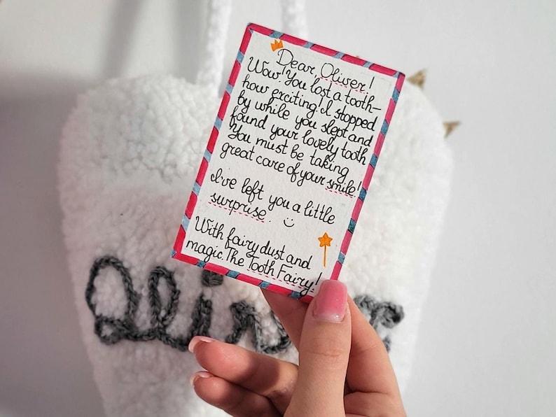 May include: A handwritten note from the Tooth Fairy to Oliver, saying "Wow! You lost a tooth- how exciting! I stopped by while you slept and found your lovely tooth. You must be taking great care of your smile! I've left you a little surprise. With fairy dust and magic. The Tooth Fairy!"