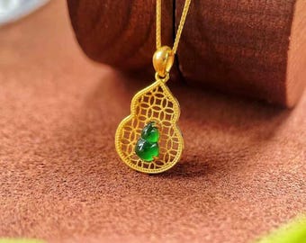 May include: A gold chain necklace with a green jade pendant shaped like a gourd. The pendant is set in a delicate gold filigree design.