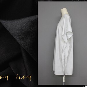 May include: A white, striped, long-sleeved dress with a loose fit. The dress is on a white mannequin against a gray background.