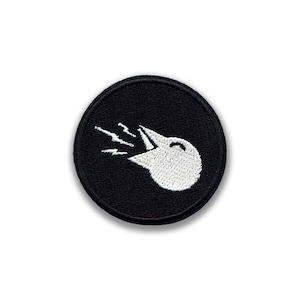 May include: A circular black embroidered patch with a white bird head design, emitting sound waves from its open beak. The patch is a simple, minimalist design, suitable for various applications, with a clean aesthetic.