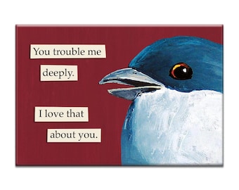 Puede incluir: Una impresión artística rectangular con un pájaro azul y blanco con el pico abierto sobre un fondo burdeos. El texto de la impresión dice: "You trouble me deeply. I love that about you."