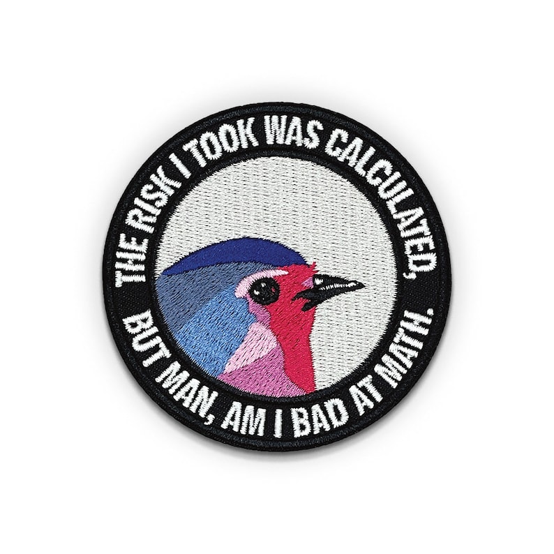Pu&ograve; includere: Una toppa ricamata in bianco e nero con un uccello colorato e il testo "THE RISK I TOOK WAS CALCULATED, BUT MAN, AM I BAD AT MATH."