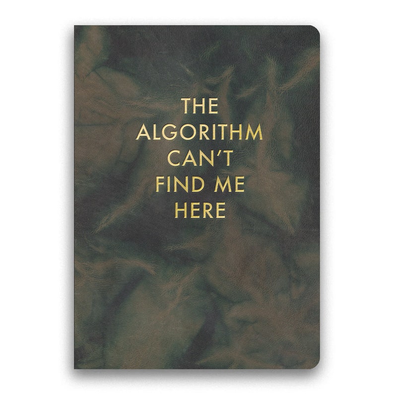 May include: A dark green leather-bound journal with the text "THE ALGORITHM CAN'T FIND ME HERE" in gold lettering.