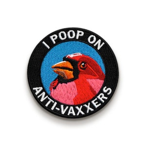 May include: A round black and white embroidered patch with a red cardinal bird on a blue background. The text on the patch reads "I POOP ON ANTI-VAXXERS".