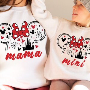 May include: White sweatshirts with a black and red Mickey Mouse design. The adult sweatshirt says "mama" and the child's sweatshirt says "mini".