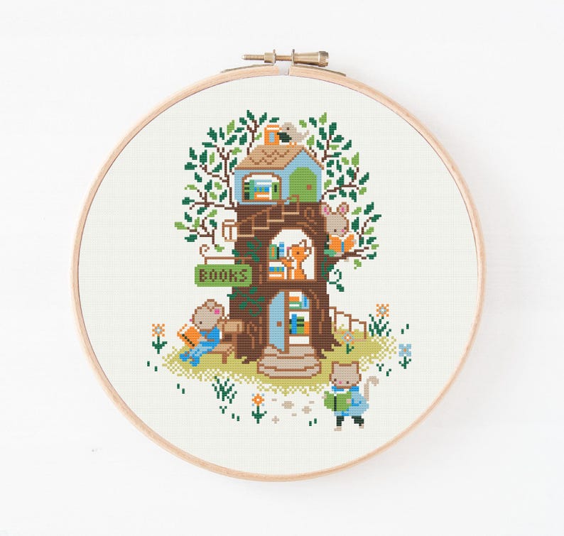 May include: Cross-stitch embroidery of a treehouse scene with woodland creatures. The treehouse has a green roof, brown trunk, and a sign that says "BOOKS". A mouse reads on a bench, a fox looks out a window, and a cat reads a book.