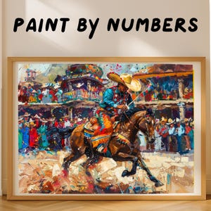 Puede incluir: Un kit de pintura por números enmarcado con una pintura vibrante de un caballo y un jinete en una escena de rodeo. El jinete lleva un sombrero y ropa colorida. El fondo muestra una multitud. El texto "PAINT BY NUMBERS" está en la parte superior.