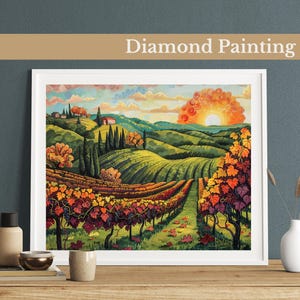Puede incluir: Pintura de diamantes de un paisaje de viñedo con colinas onduladas, una pequeña casa y una puesta de sol en el fondo. El viñedo está en plena floración con hojas rojas, naranjas y amarillas. La pintura está enmarcada en un marco blanco.