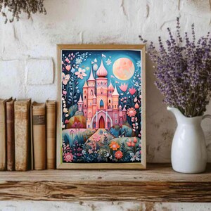 May include: A rectangular framed art print featuring a pink castle with multiple towers and spires, surrounded by stylized flowers and foliage in shades of blue, pink, and orange, set against a dark blue night sky with a large, pale yellow full moon.