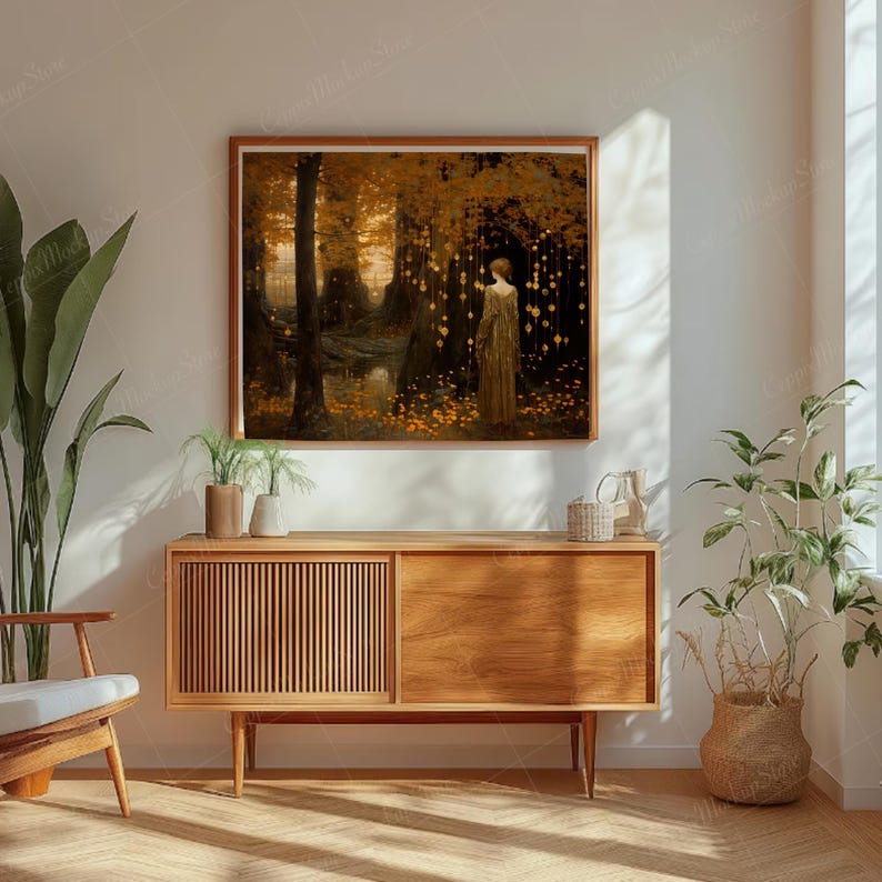 Puede incluir: Una impresi&oacute;n art&iacute;stica enmarcada representa a una mujer con un vestido dorado en un bosque con luces brillantes. La obra de arte utiliza tonos c&aacute;lidos de oro, marr&oacute;n y naranja, creando una atm&oacute;sfera serena y et&eacute;rea. La impresi&oacute;n se exhibe sobre un mueble de madera.