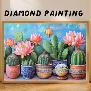 Op de afbeelding: Een ingelijste diamond painting met cactussen en lotusbloemen in decoratieve potten. Het kunstwerk heeft een blauwe en groene achtergrond met de tekst "DIAMOND PAINTING" bovenaan. De potten zijn in verschillende kleuren en patronen.
