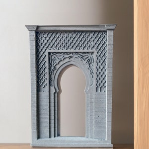 May include: A gray concrete decorative archway with intricate carvings. The archway is a traditional Moroccan design and is perfect for adding a touch of exotic flair to any home.