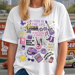 May include: White t-shirt featuring a colorful graphic design with the text "Hannah Montana" and various illustrations, including a guitar, stars, and the phrase "Best of Both Worlds."