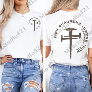 Puede incluir: Camiseta blanca con cuello redondo con un diseño de cruz marrón oscuro y el texto "IRON SHARPENS IRON PROVERBS 27:17". El diseño se repite en la parte delantera y trasera.