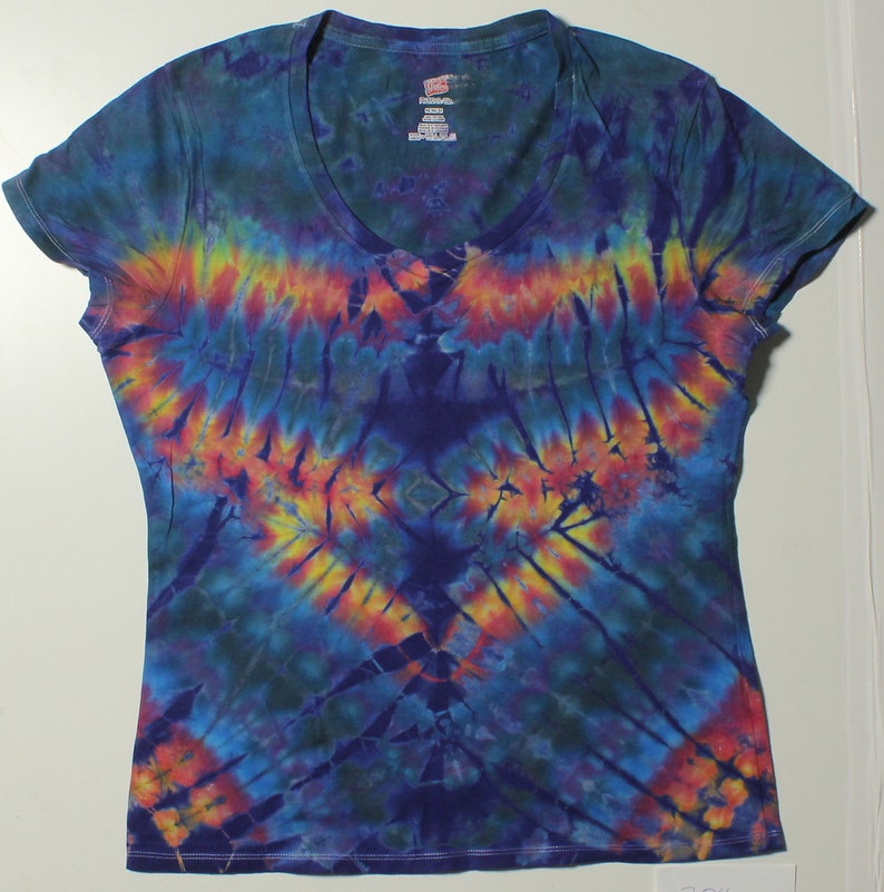 May include: A tie-dye V-neck t-shirt with a vibrant pattern of blue, yellow, orange, and red hues. The design radiates from the center, creating a symmetrical, eye-catching effect. The shirt is made of soft fabric.