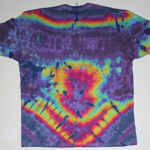 May include: A tie-dye t-shirt with a rainbow pattern in shades of purple, blue, yellow, orange, and red. The shirt has a relaxed fit and a crew neck.