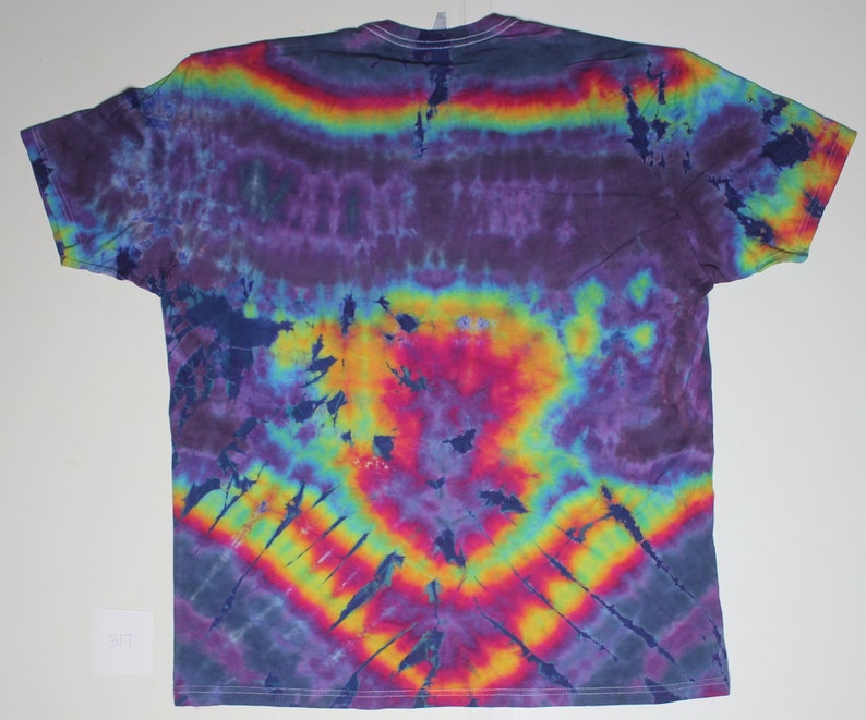 May include: A tie-dye t-shirt with a rainbow pattern in shades of purple, blue, yellow, orange, and red. The shirt has a relaxed fit and a crew neck.