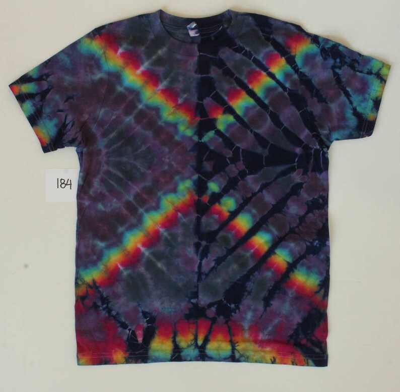 Może przedstawiać: Koszulka tie-dye z ciemnoniebieskim, fioletowym i czarnym tłem. Koszulka ma wz&oacute;r tęczy w kolorach czerwonym, pomarańczowym, ż&oacute;łtym, zielonym, niebieskim i fioletowym. Koszulka ma metkę z numerem 184.