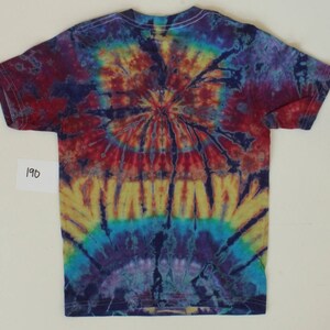 K&ouml;nnte beinhalten: Ein Batik-T-Shirt mit einem kreisf&ouml;rmigen Muster in Rot-, Orange-, Gelb-, Blau- und Violettt&ouml;nen. Das Shirt hat einen Rundhalsausschnitt und kurze &Auml;rmel.