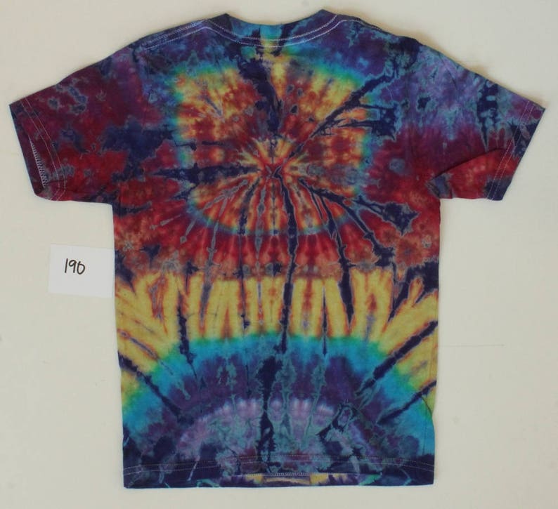 K&ouml;nnte beinhalten: Ein Batik-T-Shirt mit einem kreisf&ouml;rmigen Muster in Rot-, Orange-, Gelb-, Blau- und Violettt&ouml;nen. Das Shirt hat einen Rundhalsausschnitt und kurze &Auml;rmel.